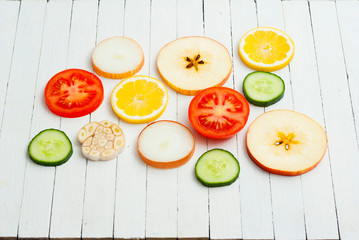 Sliced fruits, vegetables on white wooden table