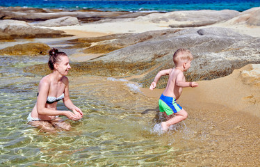 Toddler boy on beach with mother