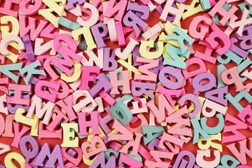 random colorful letterpress alphabet top view on red background