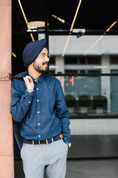 Smiling businessman leaning on door in office