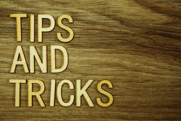 Tips and Tricks text message on wooden background
