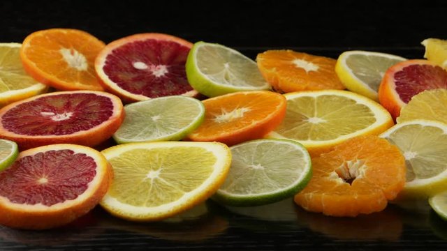 Citrus fruits in a section on a black table. Lemon, lime, orange, blood orange, mandarin. Background