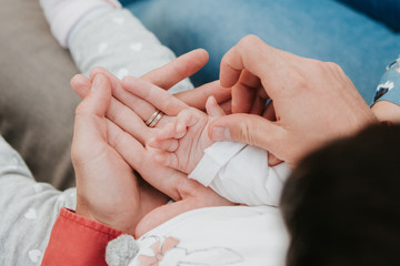 Mom and Dad hold baby's hand. Children's handle