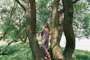 young woman hippy near a big tree