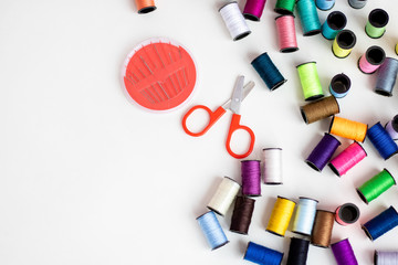 Needles with scissors and colored threads on the table