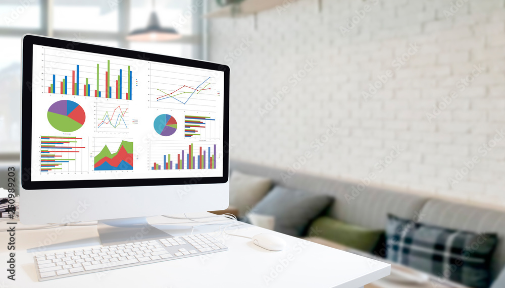 Poster Modern computer with keyboard and mouse on white table showing charts and graph on screen against modern white room  background