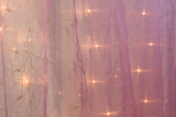background with violet organza cloth texture and led light garland