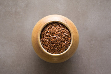 Flax seeds or linseeds in bowl pitcher on stone gray background. Flaxseed or linseed concept. Flax seed dietary fiber background