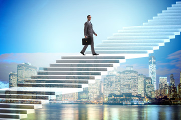 Fototapeta premium Businessman climbing career ladder over city