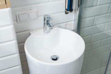 Chrome crane on the round ceramic wash basin in the bathroom
