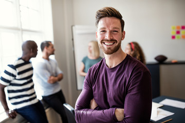 Smiling young designer standing in an office after a presentatio - Powered by Adobe