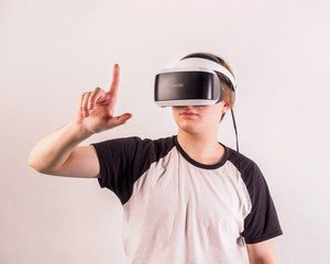 Teenage student man virtual reality headset or 3d glasses, playing video game, gesturing with his hands and catching something.