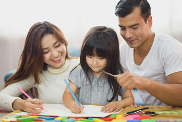 Fototapeta premium Family time Daughter laughing enjoying playing with her parent on the table in front of sofa at home.