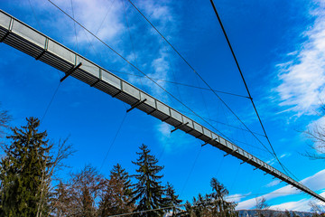 a spectacular suspension bridge (pedestrian), in iron, in the municipality of Sigriswil, in the district of Thun in the canton of Bern, Switzerland. View of mountains and lake in winter.