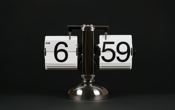 Isolated vintage flip clock on black background at six o'clock and fifty nine minutes - Powered by Adobe