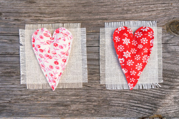 Obraz na płótnie Canvas handmade fabric hearts on a rural background, valentine's day