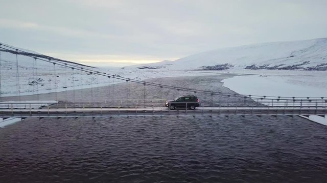 Car going the birdge over the Jokulsarlon Glacier Lagoon and black sand beach