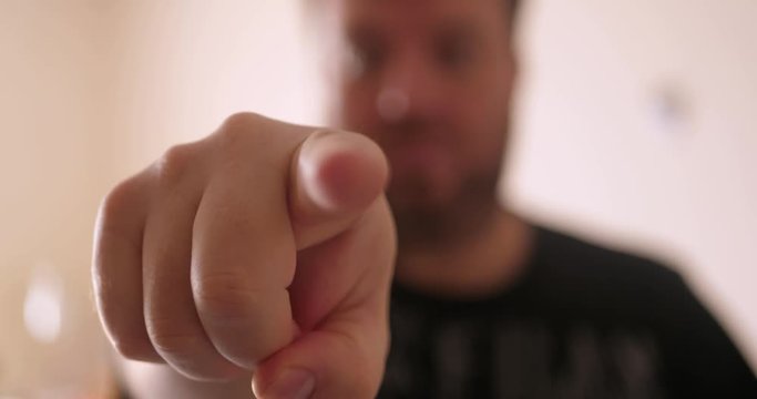 Man in out of focus points his finger towards the camera. Concept Idea