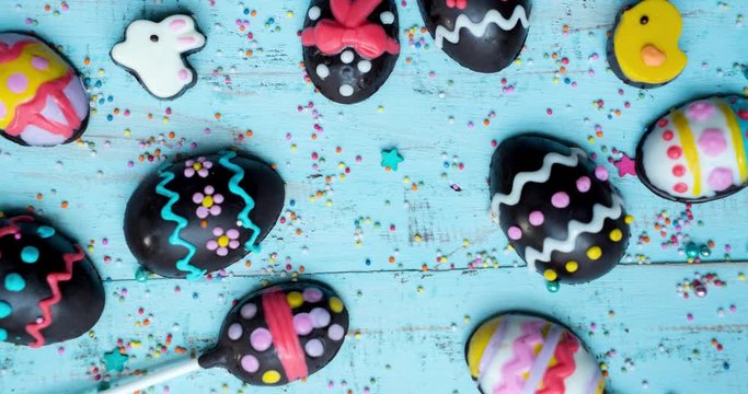 Stop motion of chocolate easter eggs with chocolate rabbit and chick on wooden table. Shot in 4k resolution