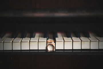 Wedding rings on the keys of the black piano
