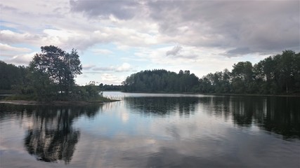 Blue sky and blue lake in summer. White clouds are reflected in the water. The famous lake Seliger. Russia.