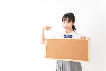 コルクボードを持つ学生