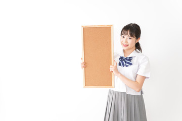 コルクボードを持つ学生