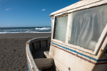 Old little wooden fishing boat on a beach in Andalusia.
