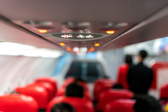 closeup airplane Console panel; lamp, light, need help button, air condition, sefty belt and no smoking lighting sign.