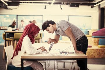 Obraz premium black muslim business woman having a meeting with her indian male colleague