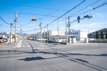 Japanese junction with traffic light and pole and electric cable, but without a car on the street