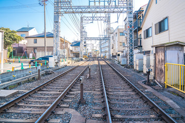 Fototapeta na wymiar local japanese railroad tracks with home and car parking beside