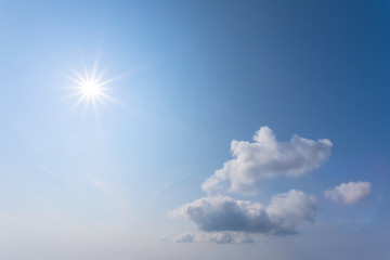 Naklejka na ściany i meble sparkle sun on a blue cloudy sky, natural background