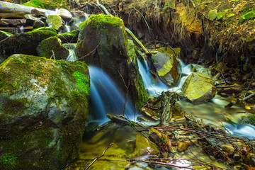 small creek rushing over a stones in the mountain canyon