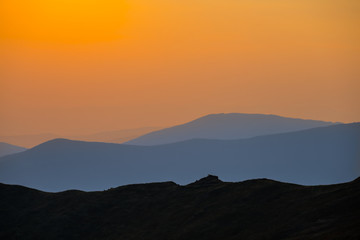 Fototapeta premium mountain ridge silhouette in a mist at the twilight