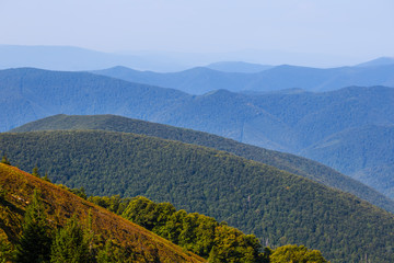 Fototapeta na wymiar green mountain chains in blue mist