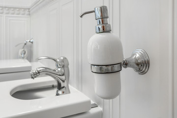 toilet and detail of a corner shower bidet with soap and shampoo dispensers on wall mount shower attachment