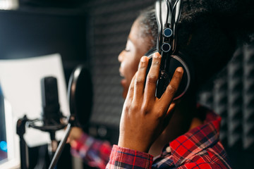 Young woman songs in audio recording studio