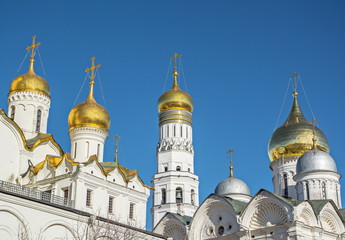 Golden crosses and domes of  Moscow Kremlin against  blue sky