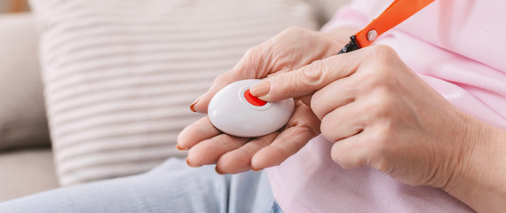 Senior woman hand pressing Alarm Button, closeup