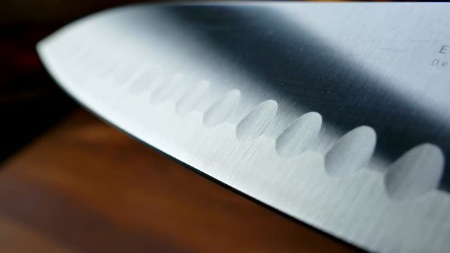 Chef's knife close-up. Knife santoku. blade blade. Drops of water flow down the blade of a knife. Cut vegetables. Cook lunch. Reflection of cold weapons.