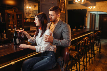 Man and woman relax, couple at wooden bar counter