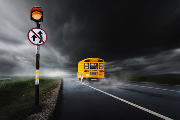 Yellow school bus (toy model) on the road with traffic signs,the rainy day.Travel / Education /...