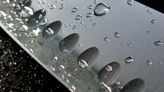 Chef's knife close-up. Knife santoku. blade blade. Drops of water flow down the blade of a knife. Cut vegetables. Cook lunch. Reflection of cold weapons.