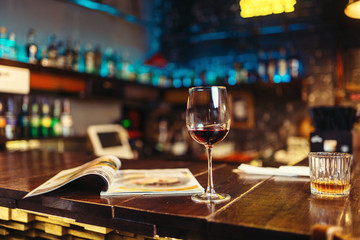 Glass of red wine on wooden bar counter, nobody