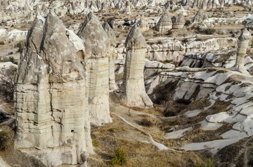 Naklejka premium The volcanic landscape of valley with natural rock formations known as fairy chimneys, located near Goreme town, Cappadocia region of Turkey