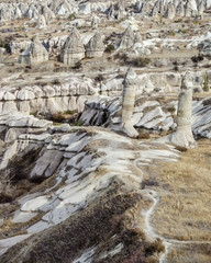 Fototapeta na wymiar The volcanic landscape of valley with natural rock formations known as fairy chimneys, located near Goreme town, Cappadocia region of Turkey