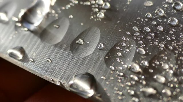 Chef's knife close-up. Knife santoku. blade blade. Drops of water flow down the blade of a knife. Cut vegetables. Cook lunch. Reflection of cold weapons.