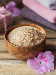 Sea salt, natural handmade soap, natural cosmetic oil and colorful towels with azalea flowers on rustic wooden background