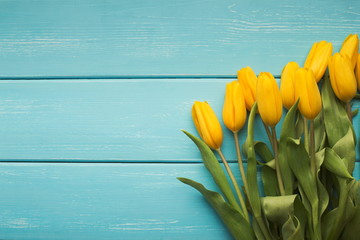 Bunch of yellow tulips on rustic wood background, copy space
